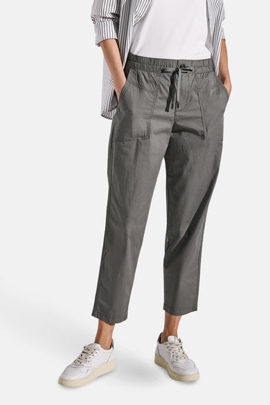 Pantalon cargo gris par Street One, avec cordon de serrage, poches plaquées et portées avec chemise rayée.