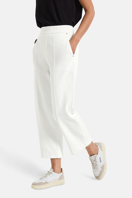 Pantalon blanc de STREET ONE, coupe ample, porté avec un t-shirt noir et des baskets beiges.