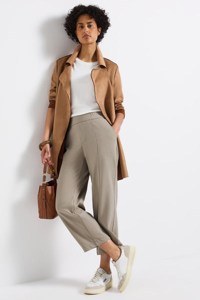 Pantalon beige de STREET ONE, coupe décontractée avec coutures décoratives et porté avec un t-shirt blanc et un manteau camel.