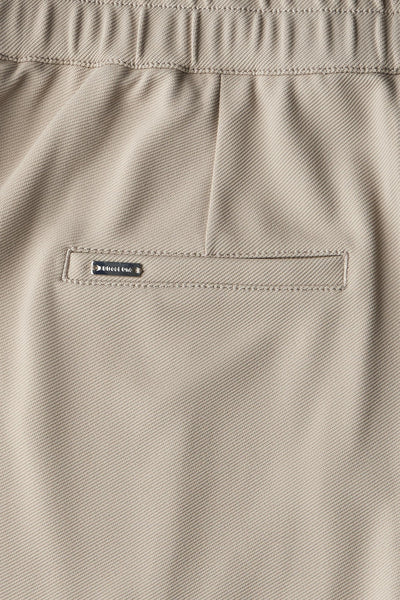 Pantalon beige de Street One, avec détails de couture et étiquette métallique discrète sur la poche arrière.
