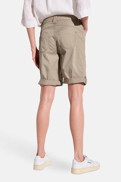 Beige Bermuda van Street One, met achterzakken en opgerolde zomen, gedragen met een wit overhemd en witte sneakers.