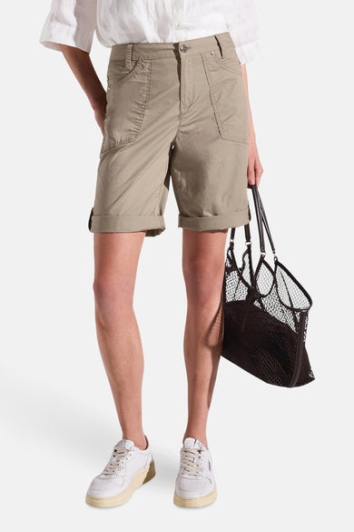 Beige Bermuda van Street One, gedragen met een nettas en witte sportschoenen.