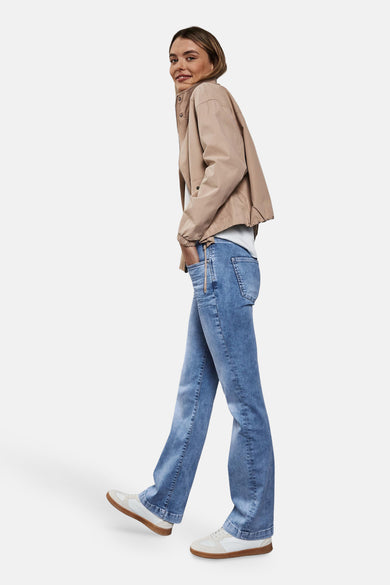 Jean bootcut en denim bleu clair de Street One, porté avec une veste beige et des baskets blanches