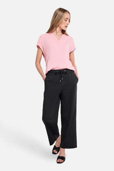 Zwarte broek van STREET ONE, wijd met een elastische tailleband met trekkoord en zwarte sandalen.
