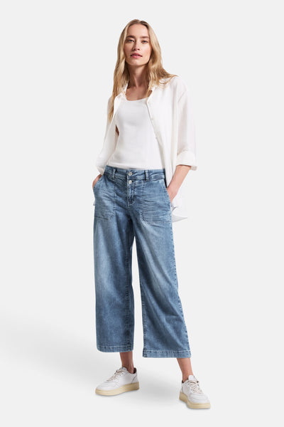 Jean large en denim bleu moyen de STREET ONE, porté avec un débardeur blanc et une chemise blanche.