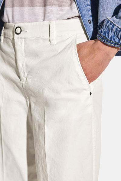 Pantalon blanc décontracté de STREET ONE, avec une main dans la poche, porté avec une veste en jean.
