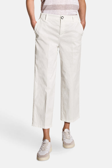 Pantalon blanc de STREET ONE, coupe cropped et jambes larges, porté avec un t-shirt rayé et des baskets blanches.
