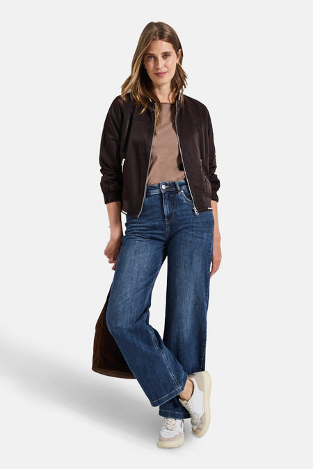 Jean large en denim bleu moyen de STREET ONE, porté avec une veste marron et des baskets.