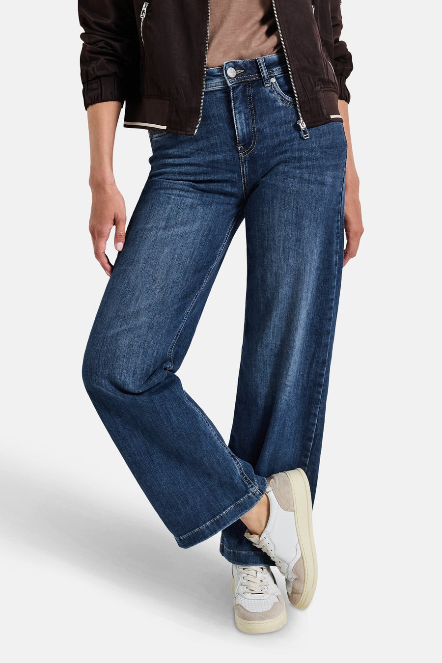 Jean large en denim bleu moyen de Street One, porté avec une veste marron et des baskets blanches.