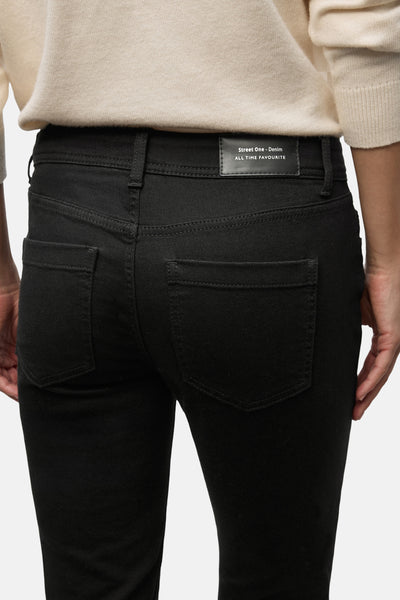Jean slim en denim noir de Street One, vue arrière, avec un pull couleur crème.
