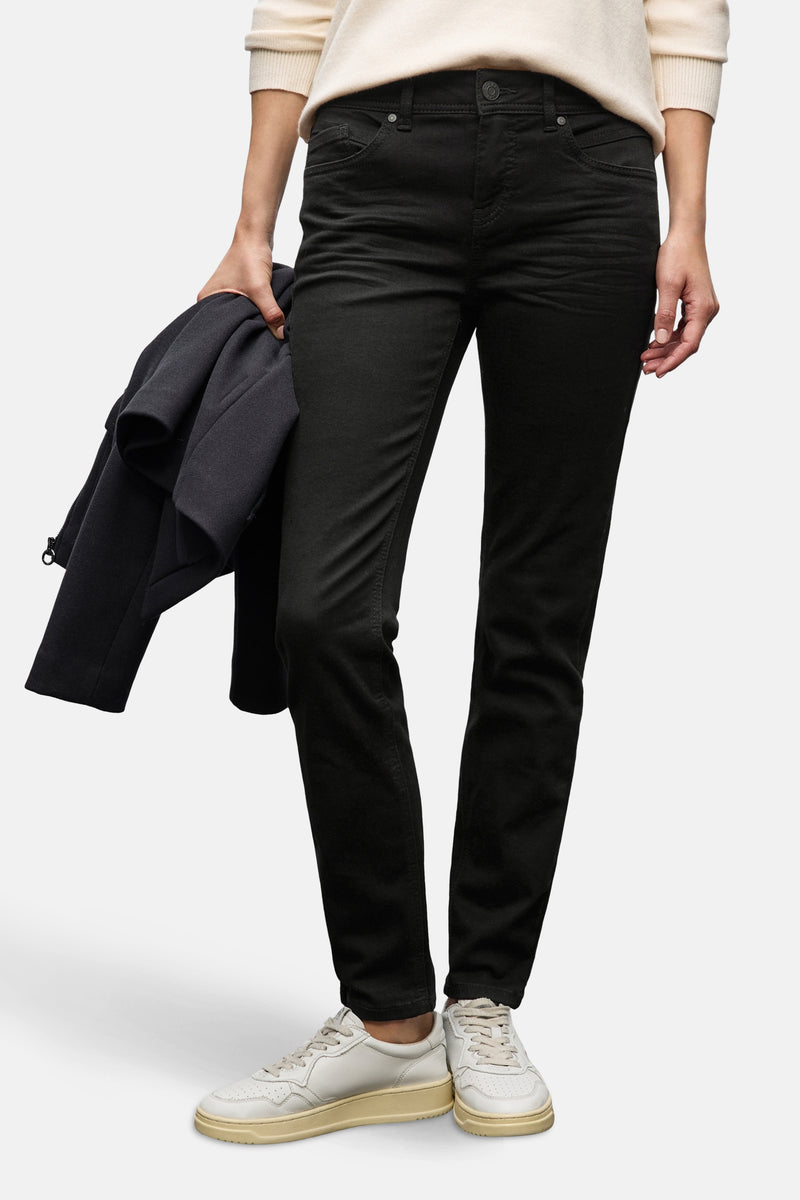 Zwarte denim slim fit jeans van STREET ONE, gedragen met een beige trui en witte sneakers.
