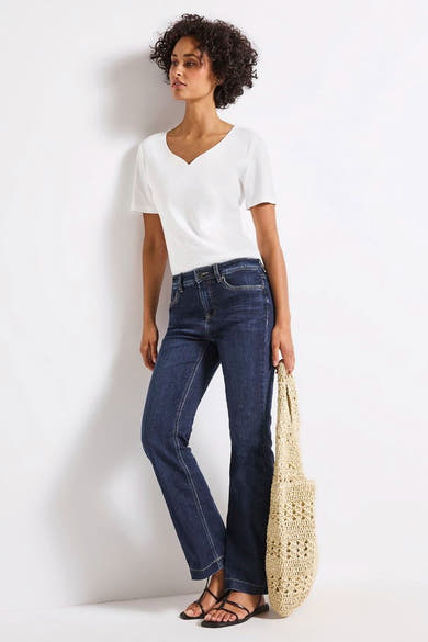 Jean bootcut en denim bleu foncé de Street One, porté avec un t-shirt blanc et des sandales noires.