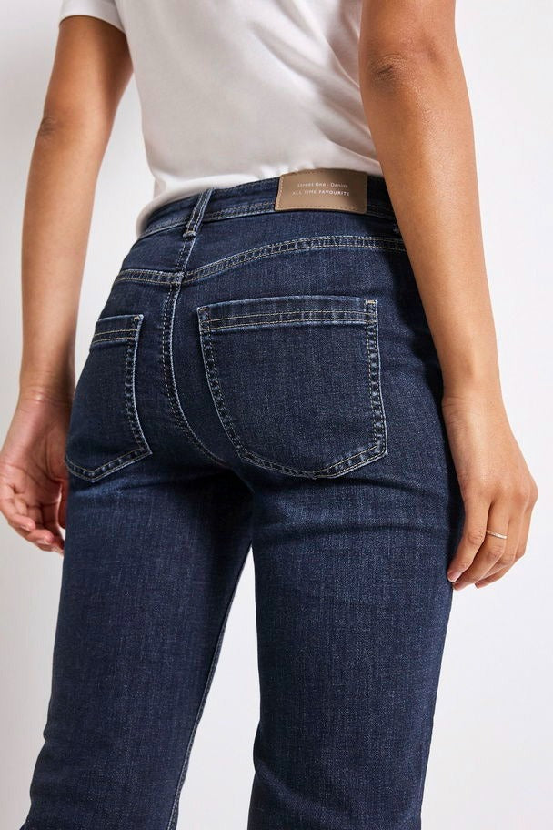 Jean bootcut en denim bleu foncé de Street One, avec des poches arrière passepoilées et un empiècement.