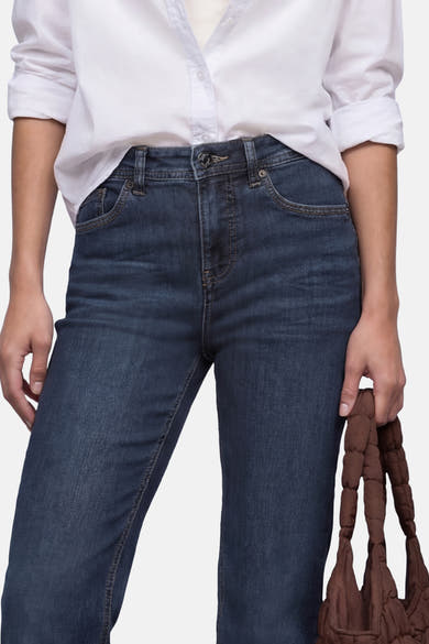 Jean bootcut en denim bleu foncé de STREET ONE, porté avec une chemise blanche et un sac marron.