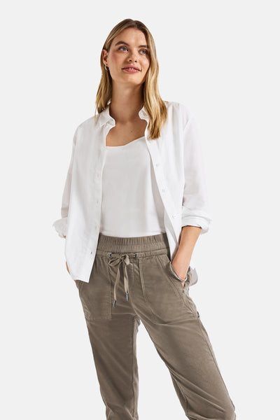 Pantalon coloré brun de STREET ONE, avec cordon de serrage, porté avec une chemise blanche et un débardeur blanc.

