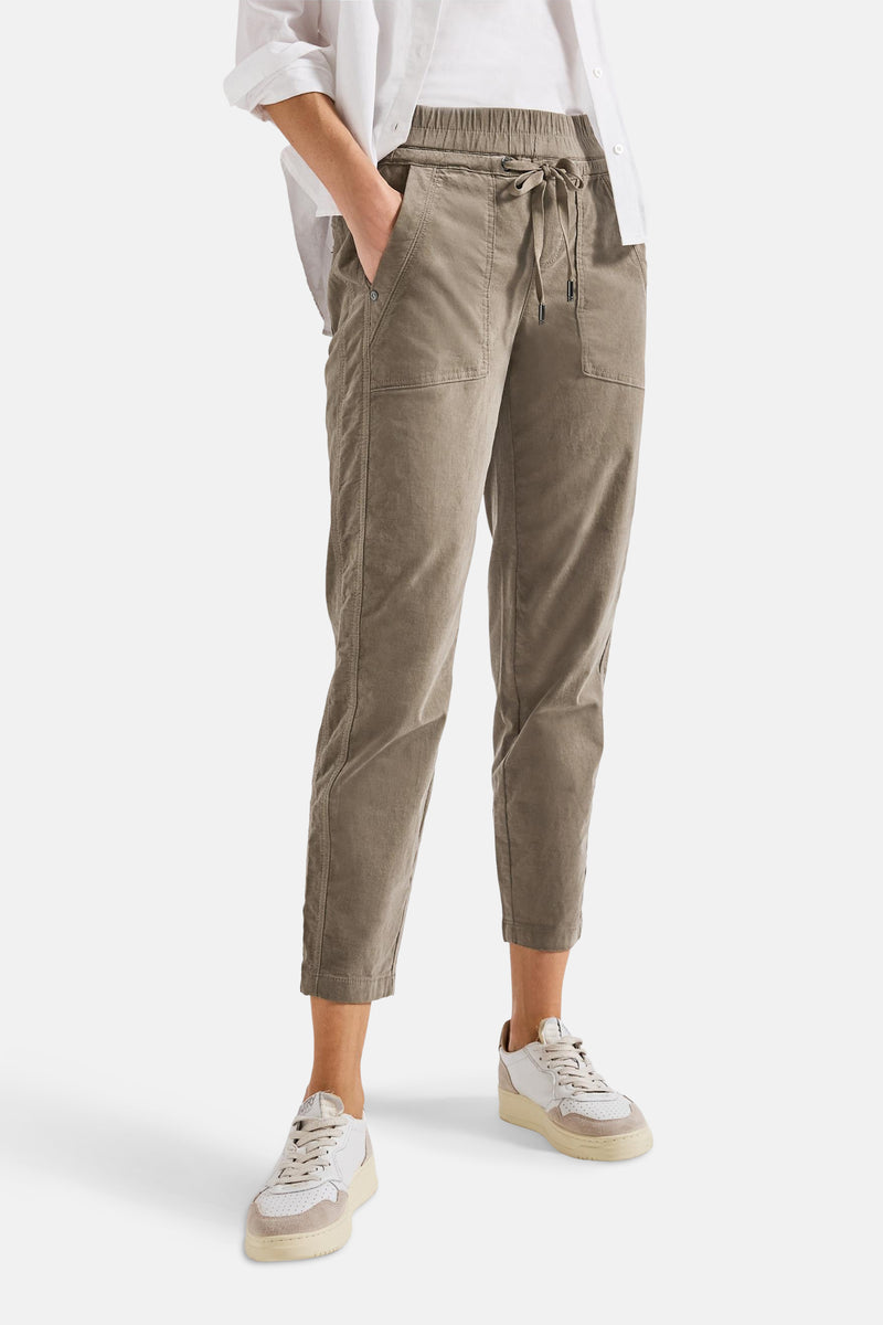Pantalon marron coloré de STREET ONE, avec poches, cordon de serrage et chaussures de sport blanches.
