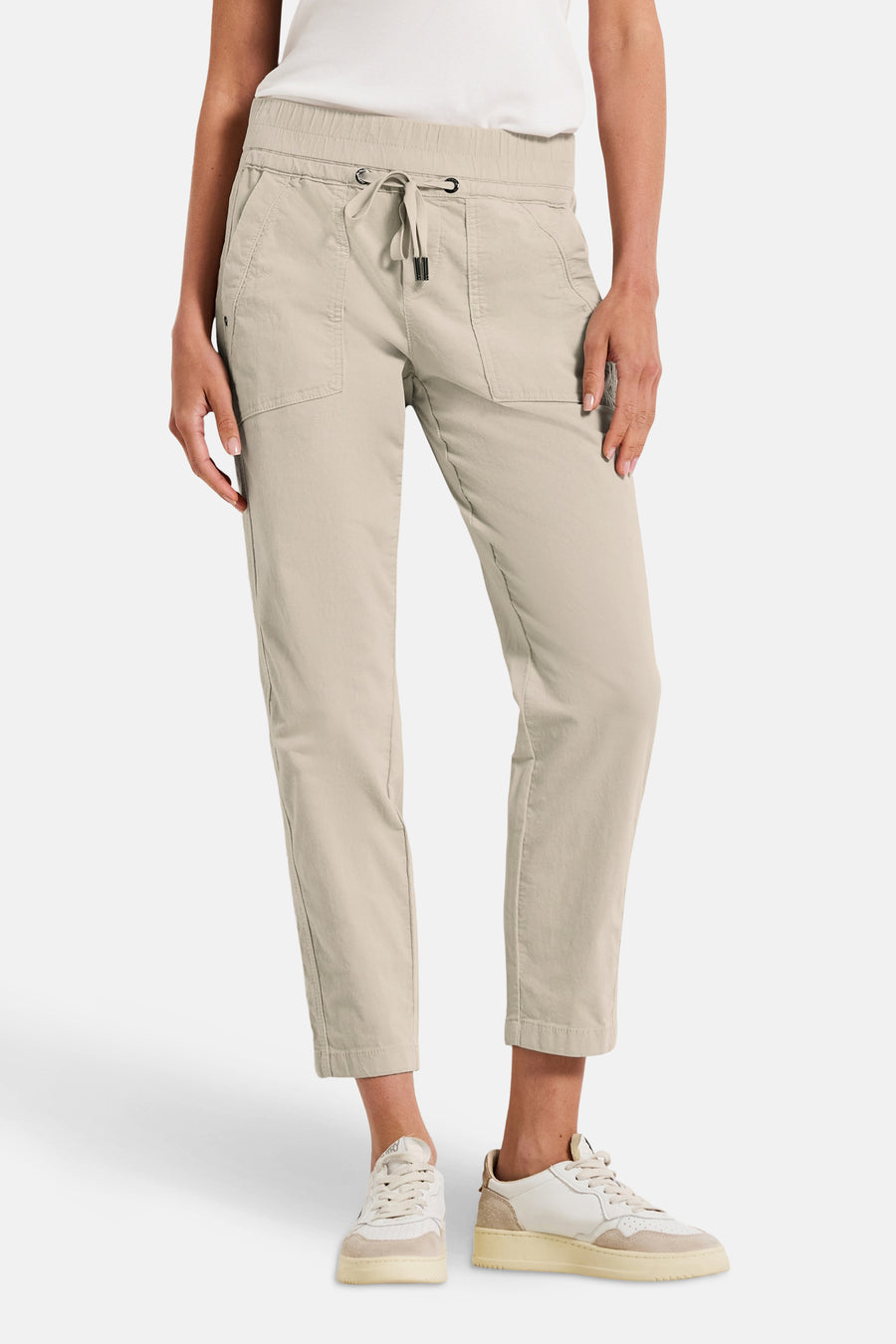 Pantalon coloré écru de Street One, avec cordon de serrage à la taille et chaussures de sport blanches en arrière-plan.