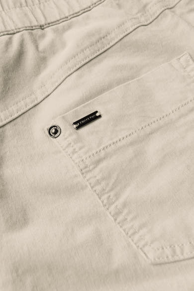 Pantalon coloré écru de STREET ONE avec une poche et détail du logo en métal.
