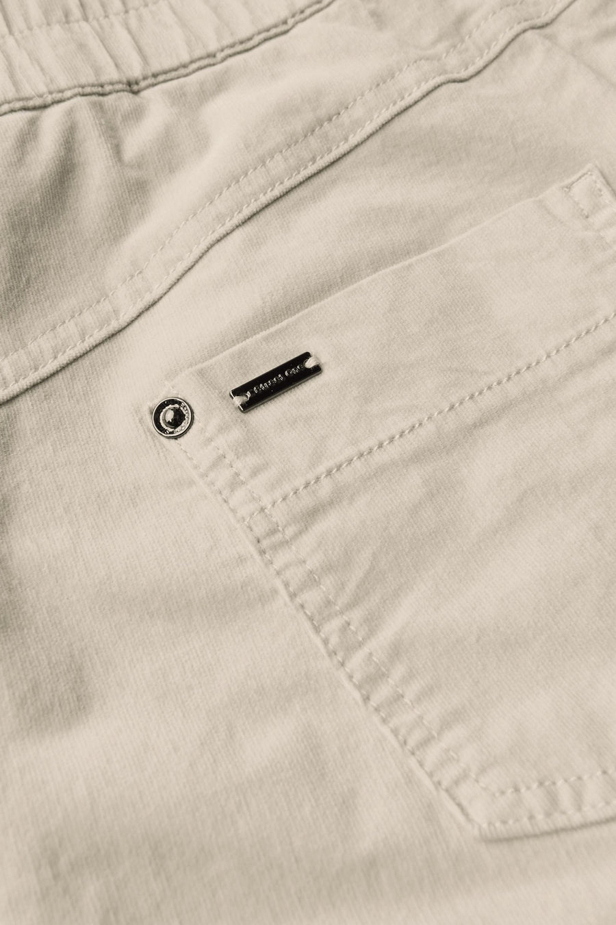 Pantalon coloré écru de STREET ONE avec une poche et détail du logo en métal.
