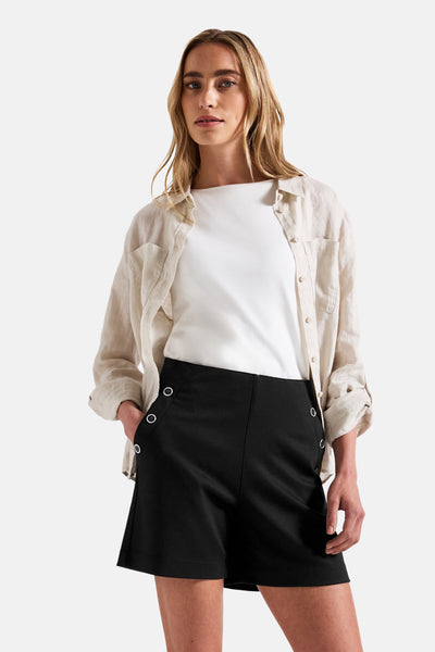 Korte zwarte rok van STREET ONE, met decoratieve knopen aan de zijkant, gedragen met een wit T-shirt en een beige blouse.