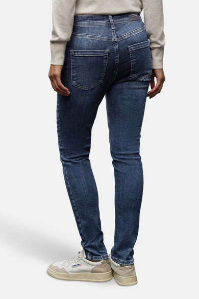 Slim jeans in donkerblauw denim van STREET ONE, gedragen met een beige trui en witte sneakers.