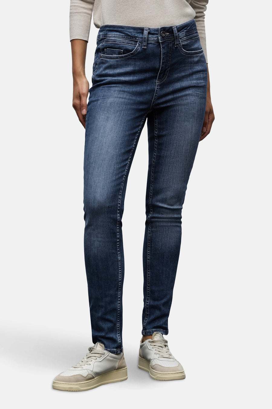 Slim jeans in donkerblauw denim van Street One, gedragen met een trui en casual sneakers.
