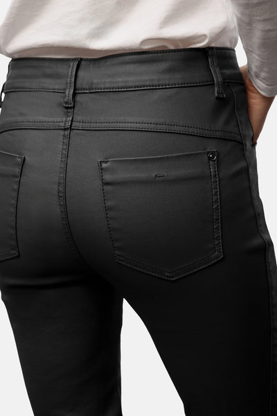 Pantalon noir de STREET ONE, avec poches arrière et texture lisse, porté avec un haut blanc.