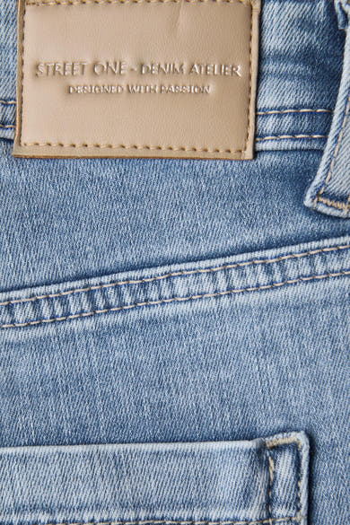 Slim jeans in lichtblauw denim van STREET ONE, met beige label van imitatieleer en zichtbare stiksels.