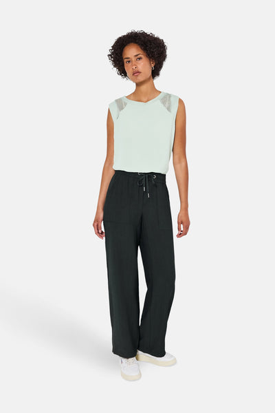 Wijdvallende groene broek van STREET ONE, met zakken, trekkoord en witte schoenen.
