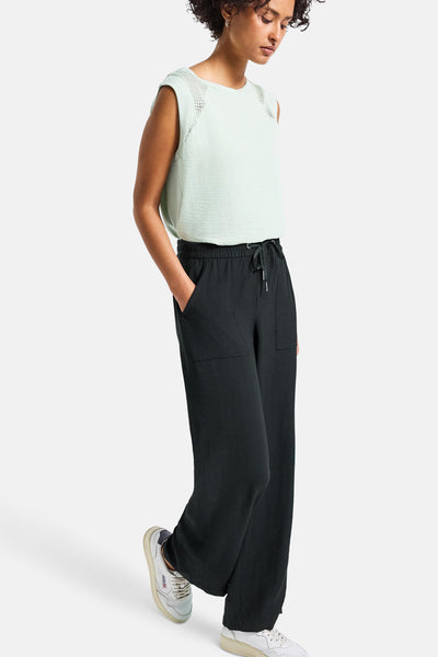 Pantalon noir décontracté de Street One, avec poches, cordon de serrage et chaussures de sport blanches.