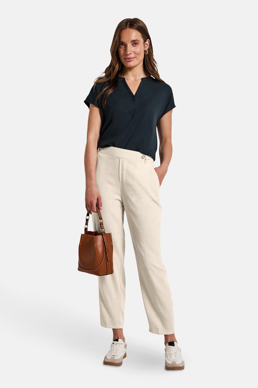 Beige broek van STREET ONE, met een subtiele textuur, gedragen met een bruine handtas en witte sneakers.
