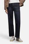 Jean large en denim bleu foncé de STREET ONE, porté avec un manteau en fausse fourrure marron et des baskets blanches.
