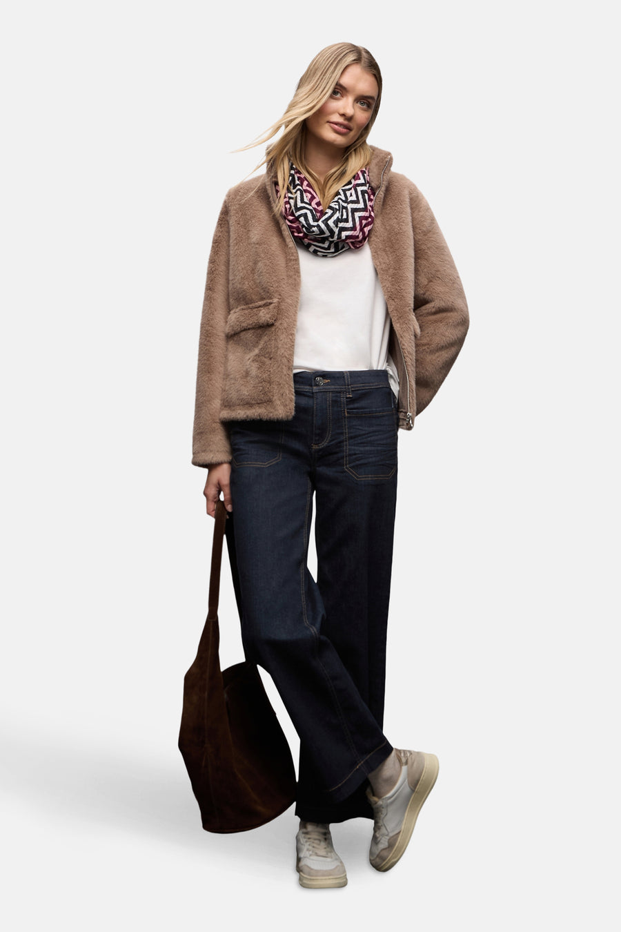 Jean large en denim bleu foncé de STREET ONE, porté avec un manteau texturé et un foulard à motifs.
