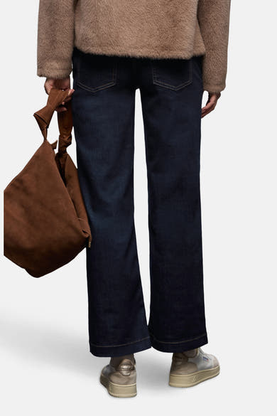 Jean large en denim bleu foncé de Street One, porté avec un pull en fausse fourrure marron et un sac en daim.