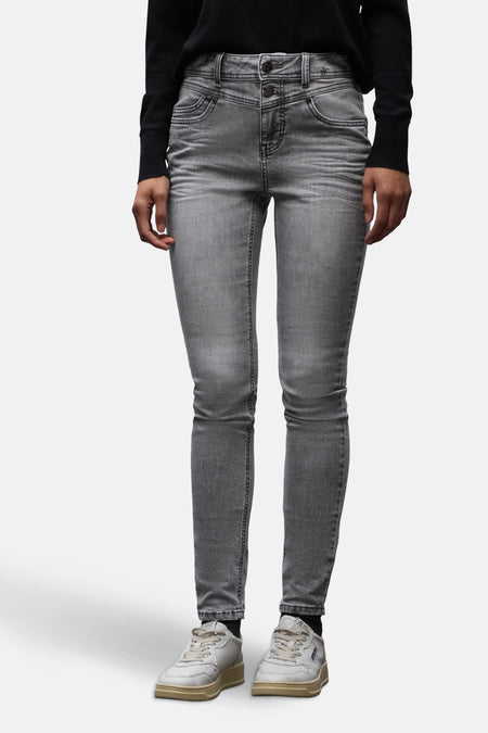 Slim jeans in middengrijs denim van STREET ONE, gedragen met een zwarte jas en witte sneakers.