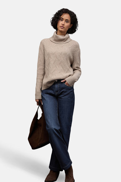 Jean large en denim bleu foncé de Street One, porté avec un pull beige et des bottines marron.
