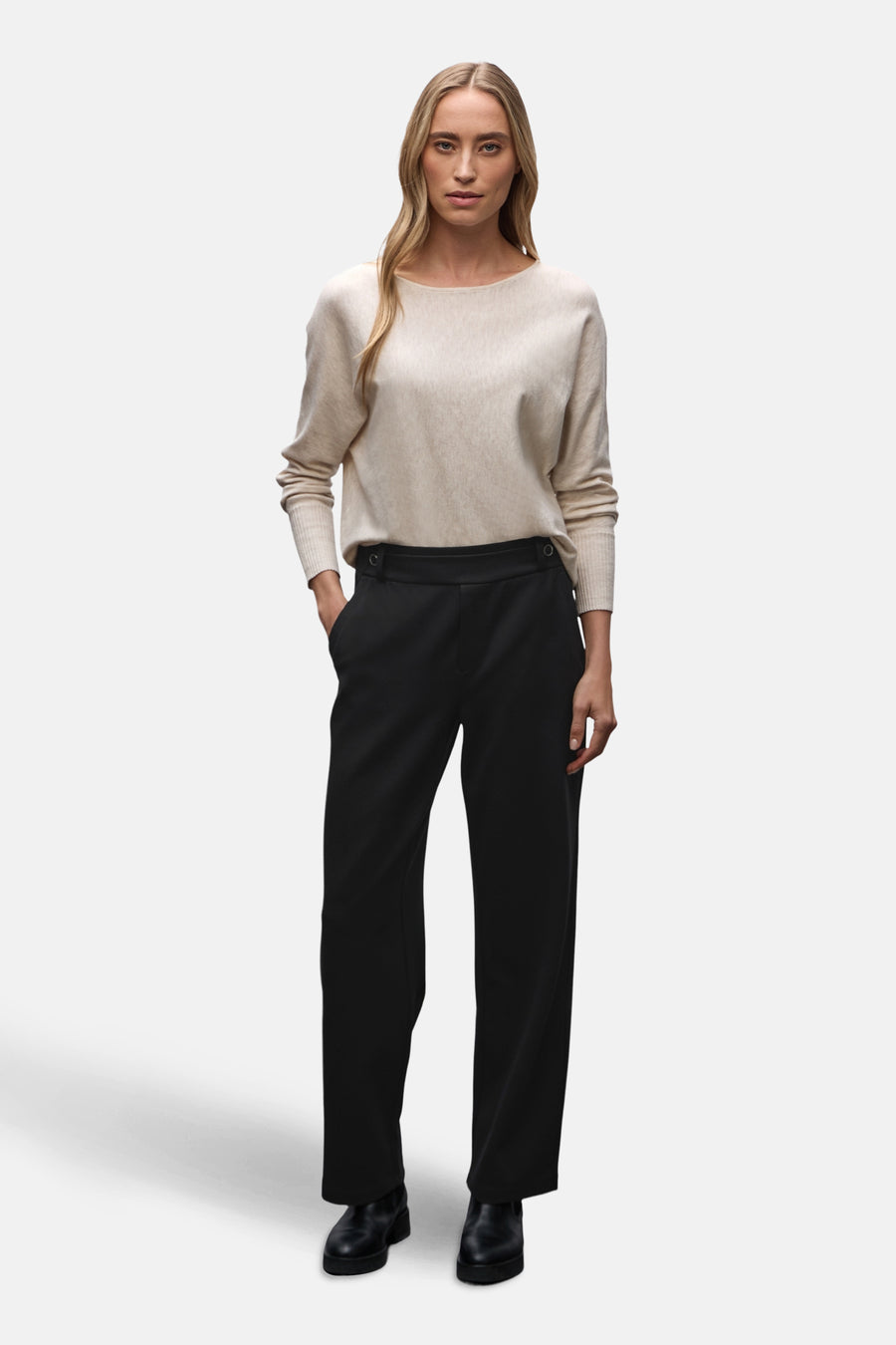 Zwarte kostuumbroek van Street One, gedragen met een beige trui en zwarte schoenen.