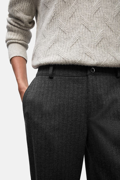 Zwarte pantalon van STREET ONE, met visgraatmotief en een hand in de zak.