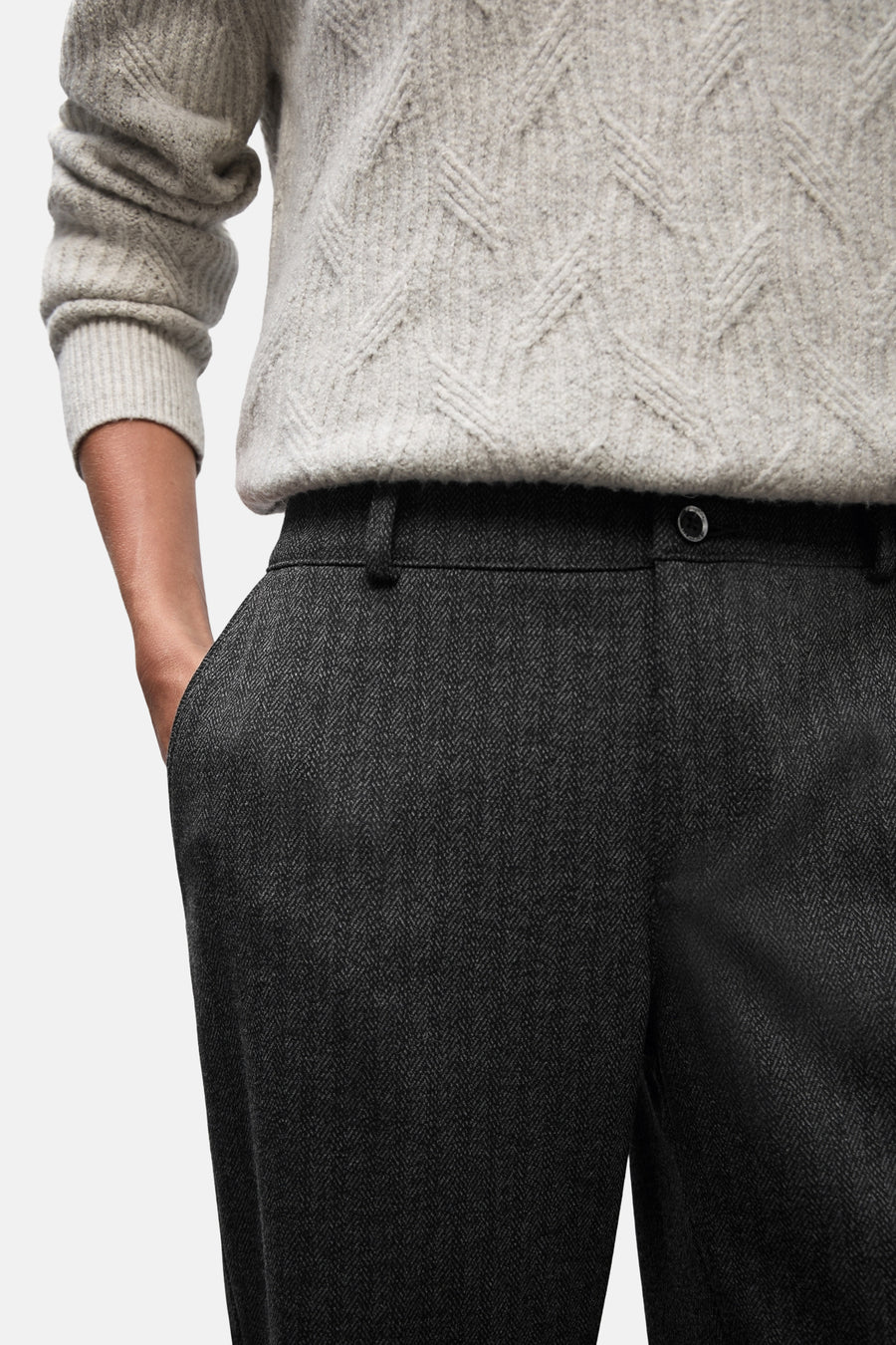 Zwarte pantalon van STREET ONE, met visgraatmotief en een hand in de zak.