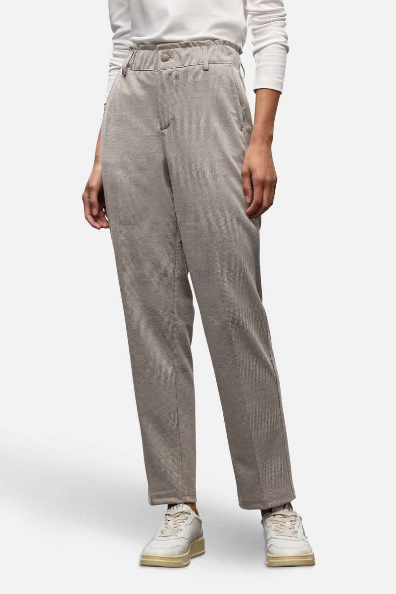 Pantalon de costume beige de Street One, à motif texturé, porté avec un haut blanc et des baskets.