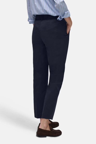 Chino bleu de STREET ONE, avec poches latérales, porté avec une chemise rayée et des mocassins marron.