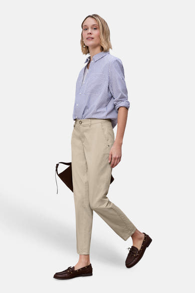 Chino beige de STREET ONE, porté avec une chemise rayée bleu et blanc et des mocassins marron.
