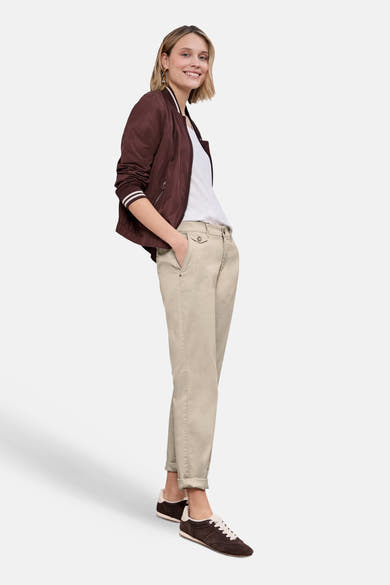 Chino beige de Street One porté avec un t-shirt blanc et une veste bordeaux, et des baskets marron.