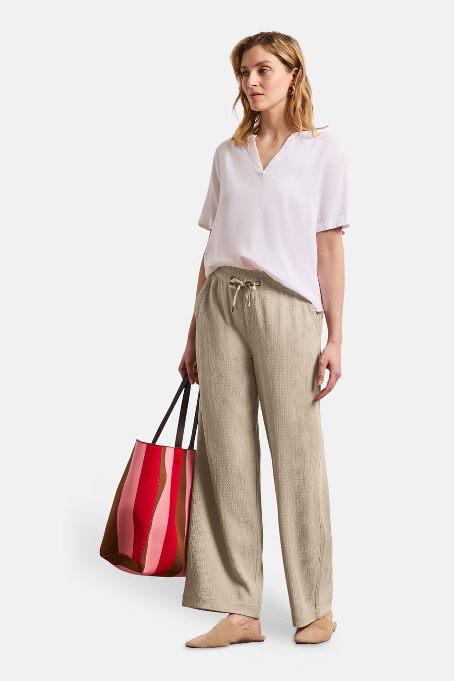 Pantalon beige de STREET ONE, coupe large texturée avec cordon de serrage, porté avec un chemisier blanc.