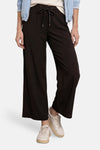 Pantalon noir de STREET ONE à taille élastique et cordon noué, coupe large, porté avec des baskets claires.