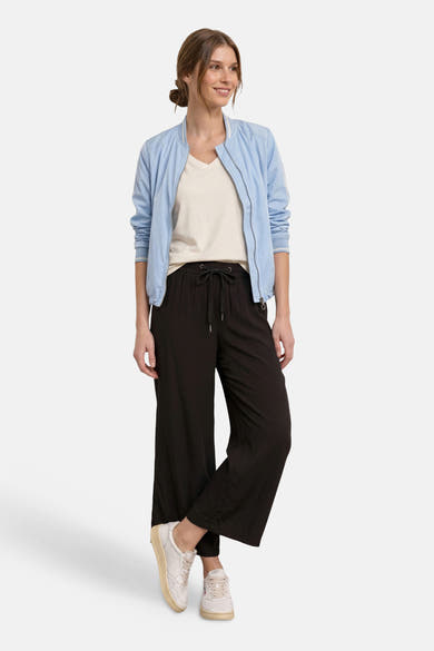 Pantalon noir de STREET ONE à taille à cordon, coupe large, porté avec une veste bomber et des baskets.