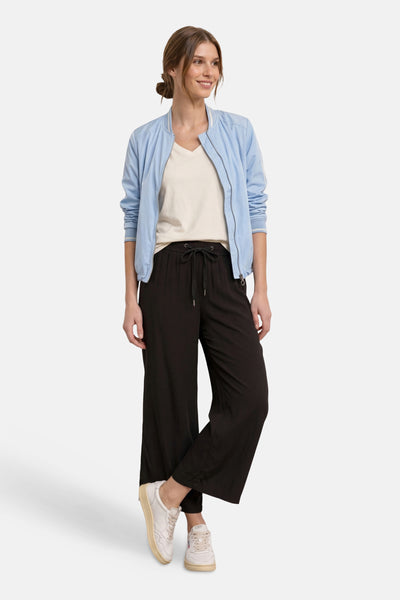 Pantalon noir de STREET ONE à taille à cordon, coupe large, porté avec une veste bomber et des baskets.