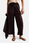 Pantalon brun fluide de STREET ONE avec taille élastiquée et cordon, porté avec un haut clair et des sandales tressées.