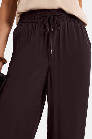 Pantalon brun de STREET ONE, coupe fluide, à taille élastiquée avec cordon de serrage et œillets métalliques, porté avec un haut clair.
