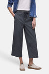 Pantalon bleu marine rayé blanc de STREET ONE, coupe large avec taille élastiquée et cordon de serrage, porté avec une chemise en jean et des baskets claires.